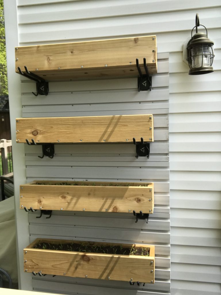 Cedar planters mounted vertically to the side of the house